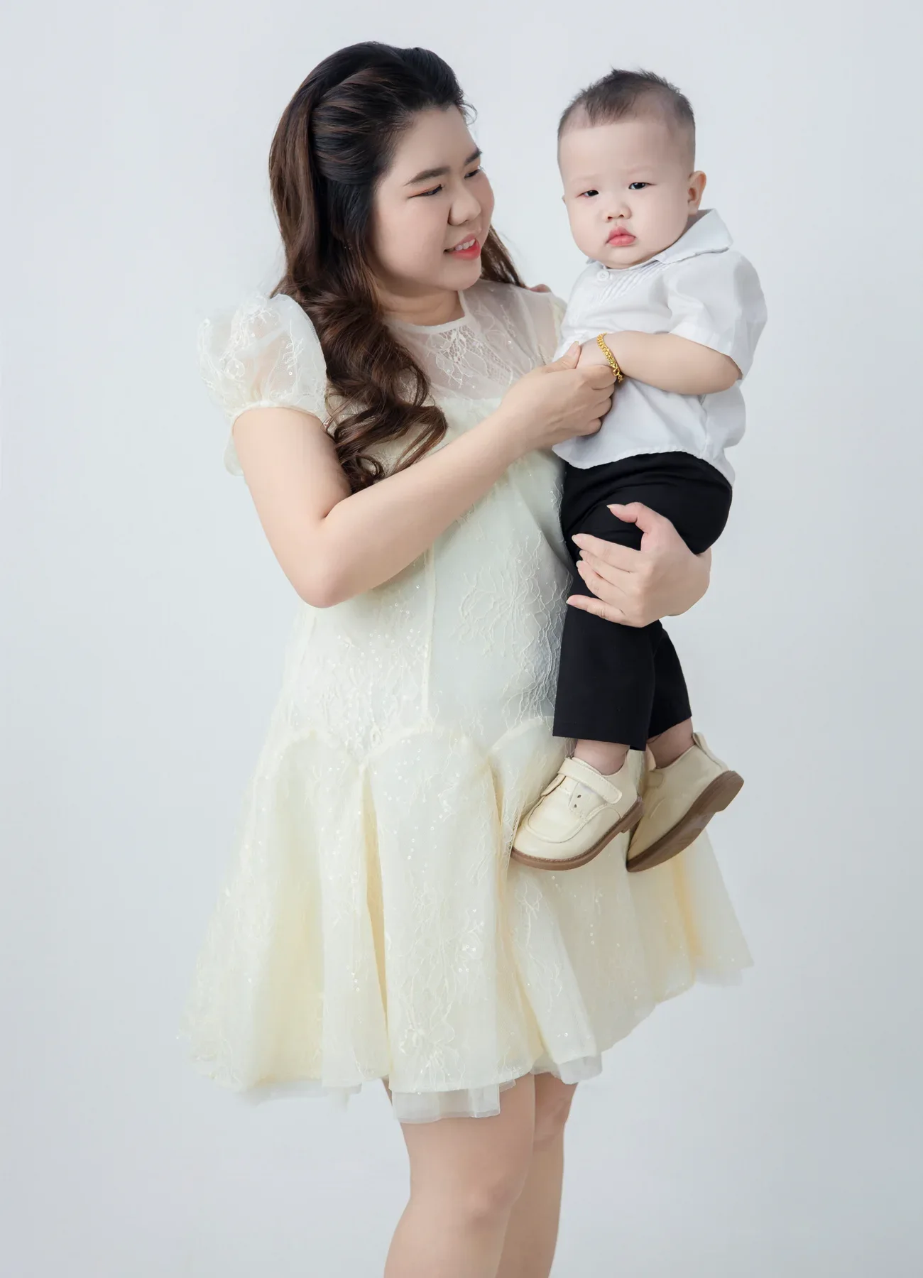 Mẹ mặc váy sáng màu bế em bé