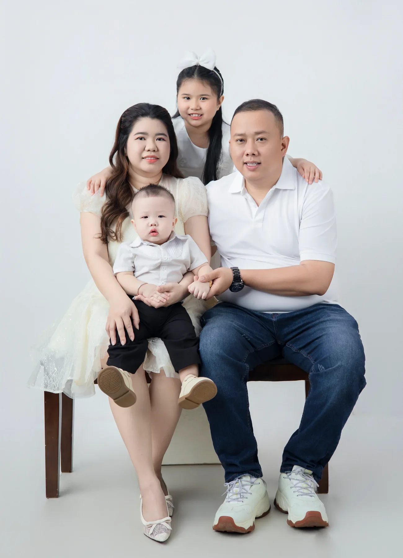 Bố mẹ ngồi cùng con gái và em bé